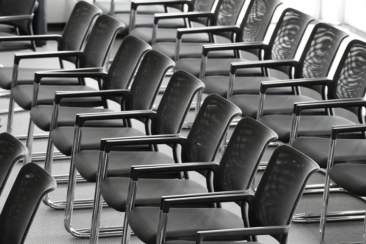 Rows of office chairs stacked after a floor was stripped out
